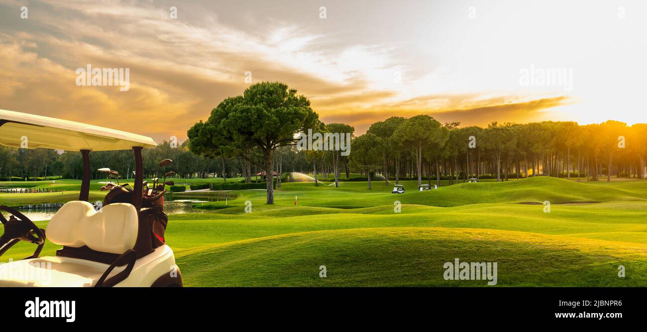 Golf cart on beautiful golf course at sunset stock photo