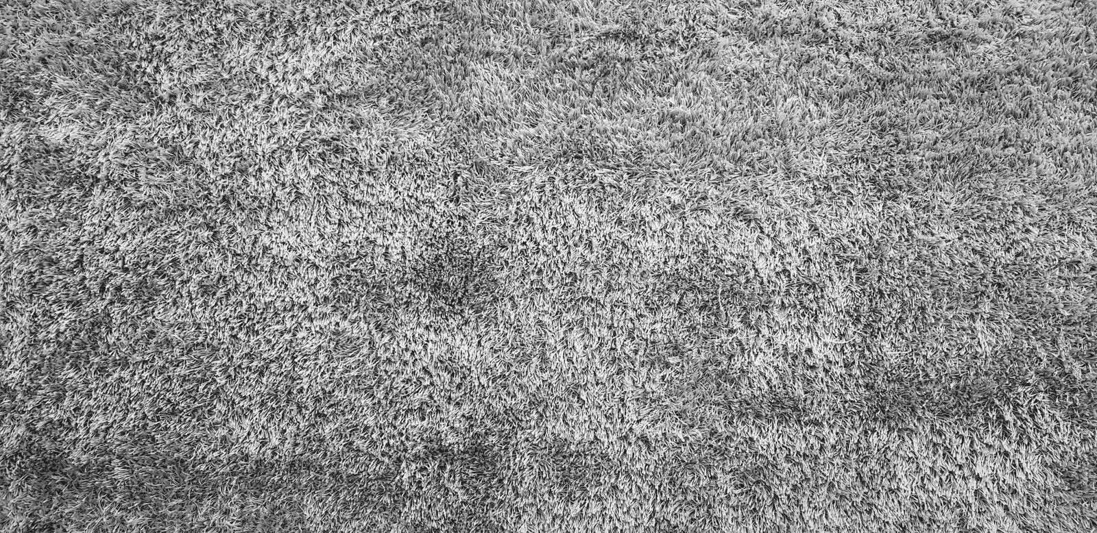 Textured of gray or grey wool carpet or rug for background or wallpaper stock image