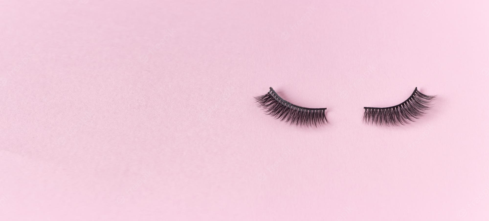 Premium photo artificial eyelashes on a pink background free space for text the concept of eyelash extensions makeup