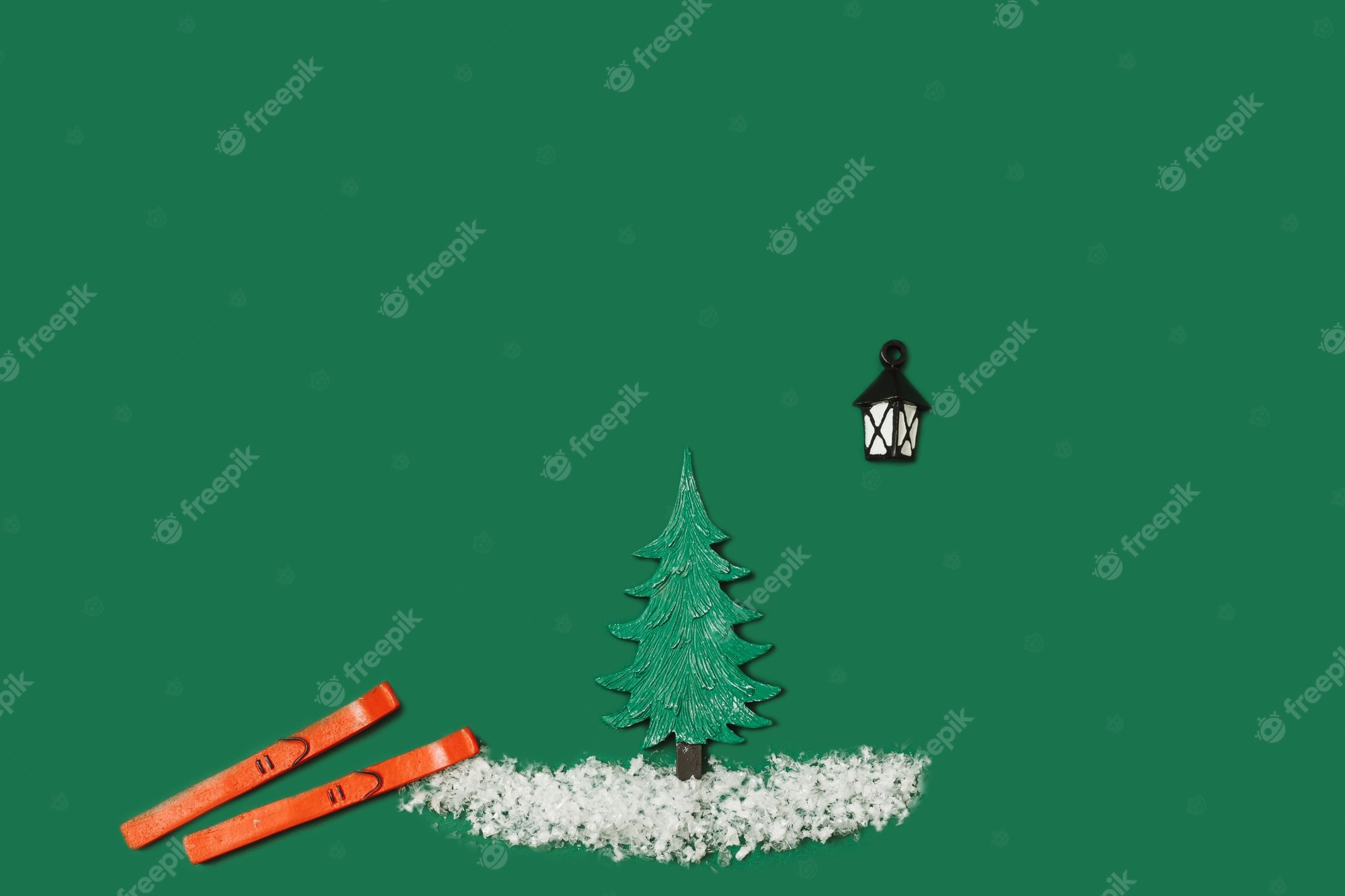Premium photo creative christmas pattern made of green toy christmas tree white fake snow flakes and red skis on green background minimal new year holiday idea top view wallpaper
