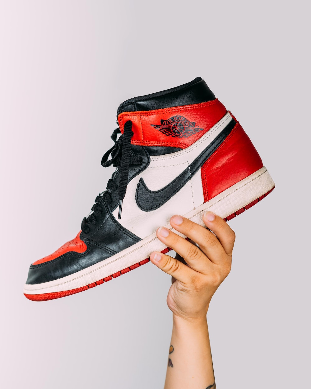 Person holding red and white nike air jordan shoe photo â free shoe image on