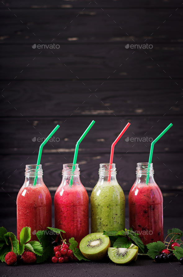 Fresh healthy smoothies from different berries on a dark background stock photo by timolina