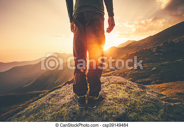 Young man traveler feet standing alone with sunset mountains on background lifestyle travel concept outdoor canstock