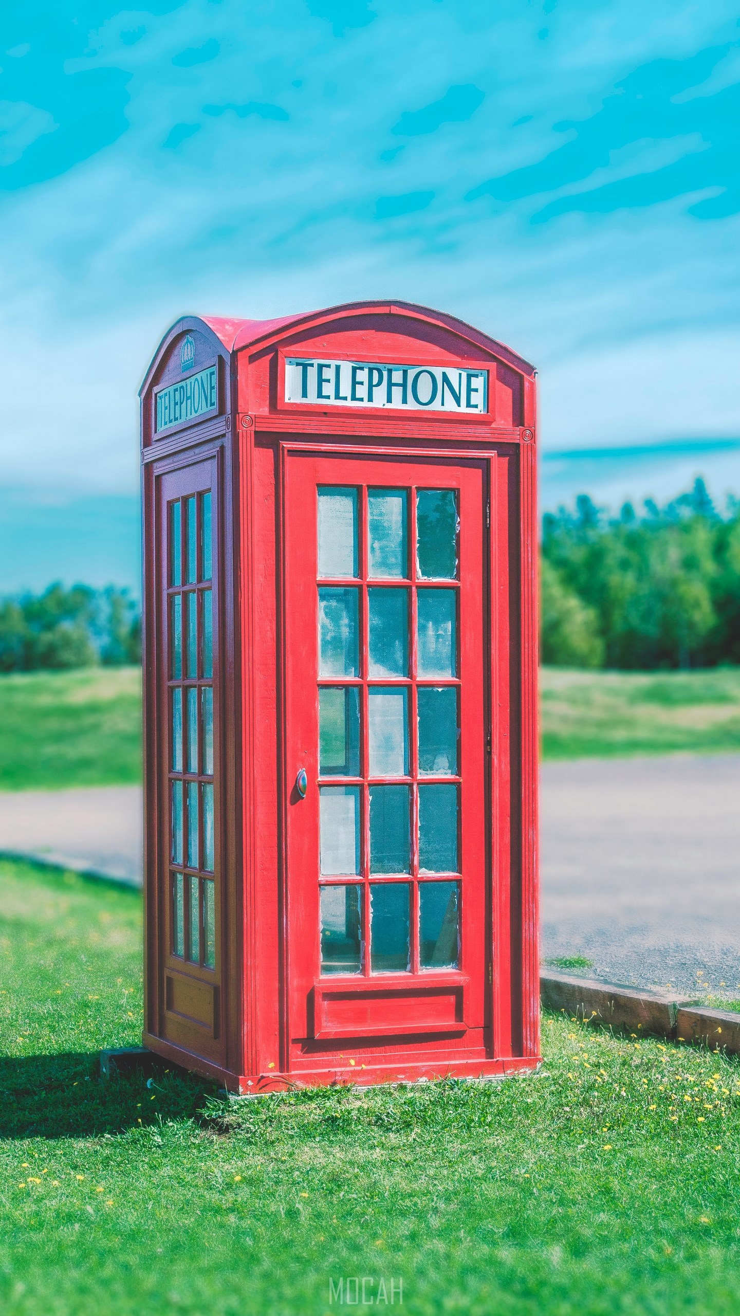 A red telephone booth sits on green grass against a blue sky telephone booth in grass htc wallpaper download x