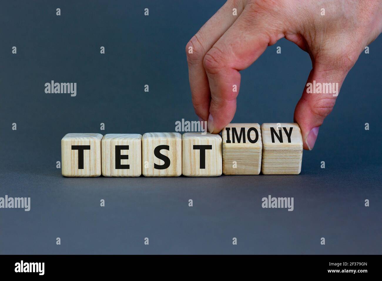 Test or testimony symbol businessman turns wooden cubes and changes the word test to testimony beautiful grey background business test or test stock photo