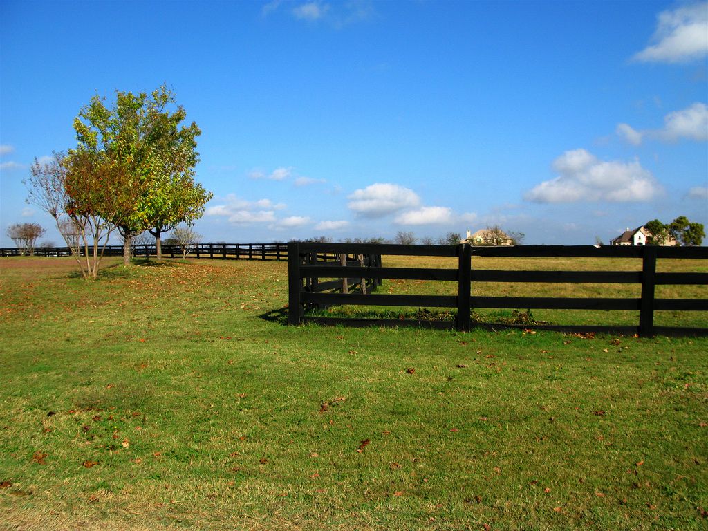 Ranches and farms backgrounds texas ranch with winding fence under blue sky
