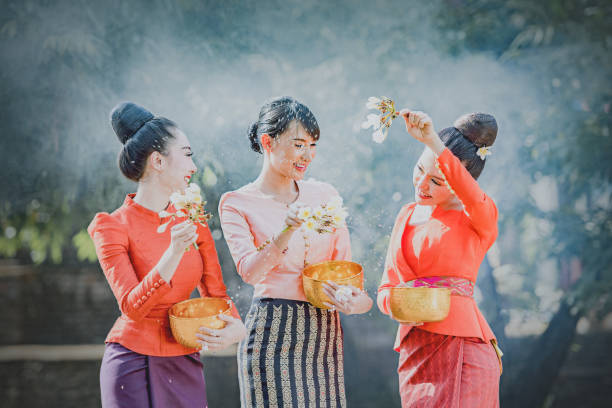Thai girls and laos girls splashing water during songkran festival stock photo