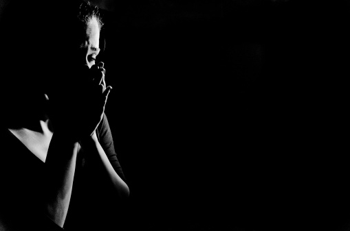 Woman in shadows crying on black stock photo