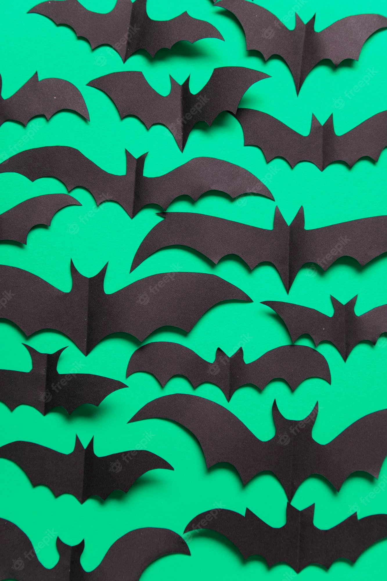 Premium photo halloween paper vampire bat decorations on a green background