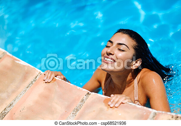 Beautiful arab woman relaxing in swimming pool beautiful arab woman relaxing in swimming pool with eyes closed with canstock