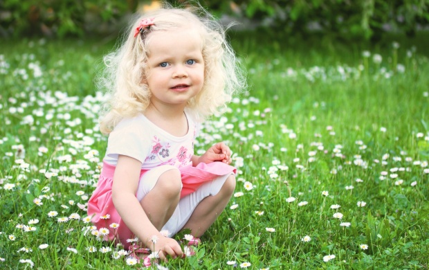 Little Girl Is Sitting On Green Meadow