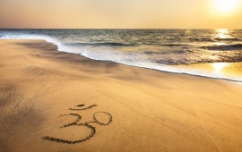 Om Symbol At Beach Sand Ocean