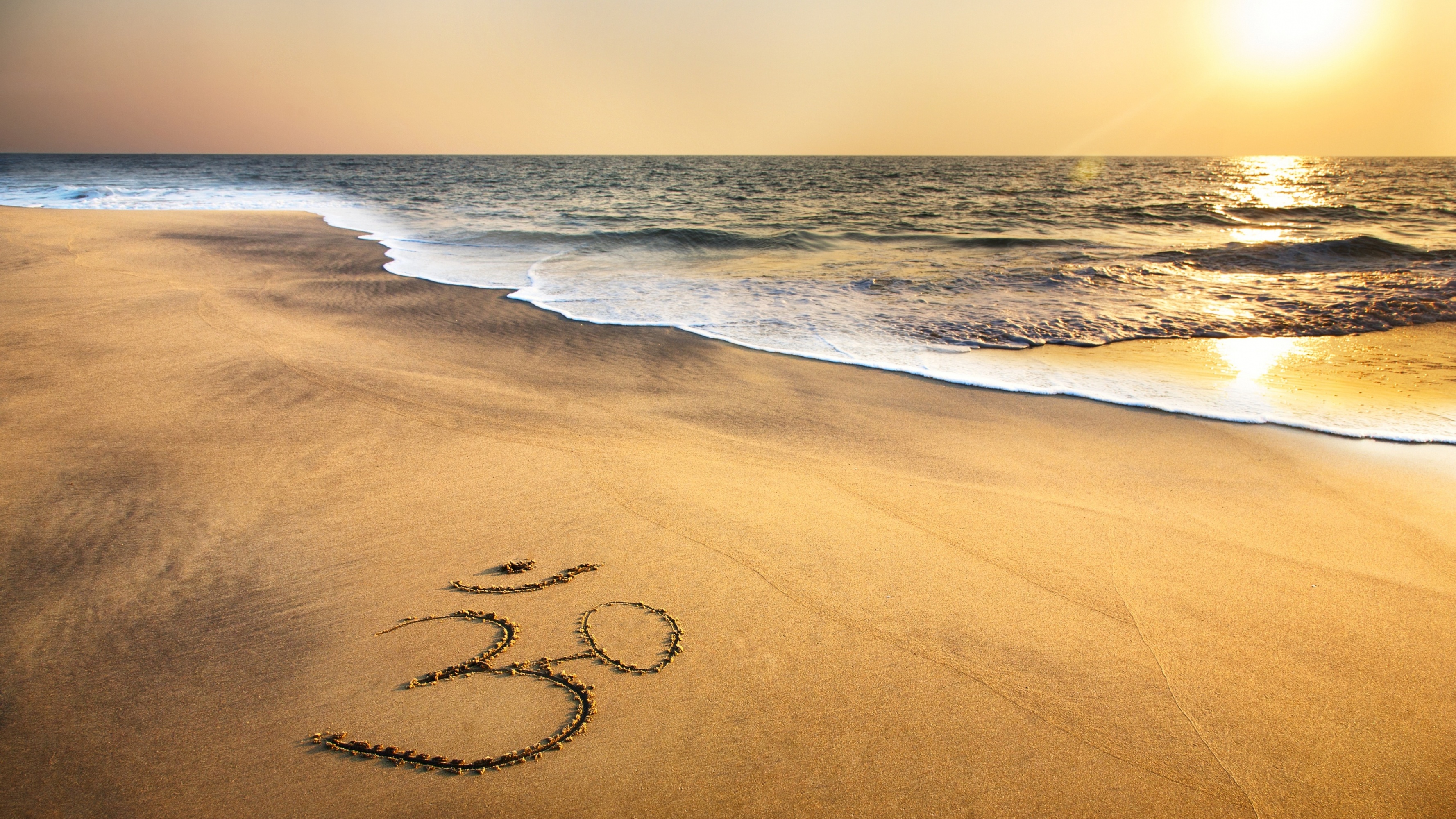 Om Symbol At Beach Sand Ocean